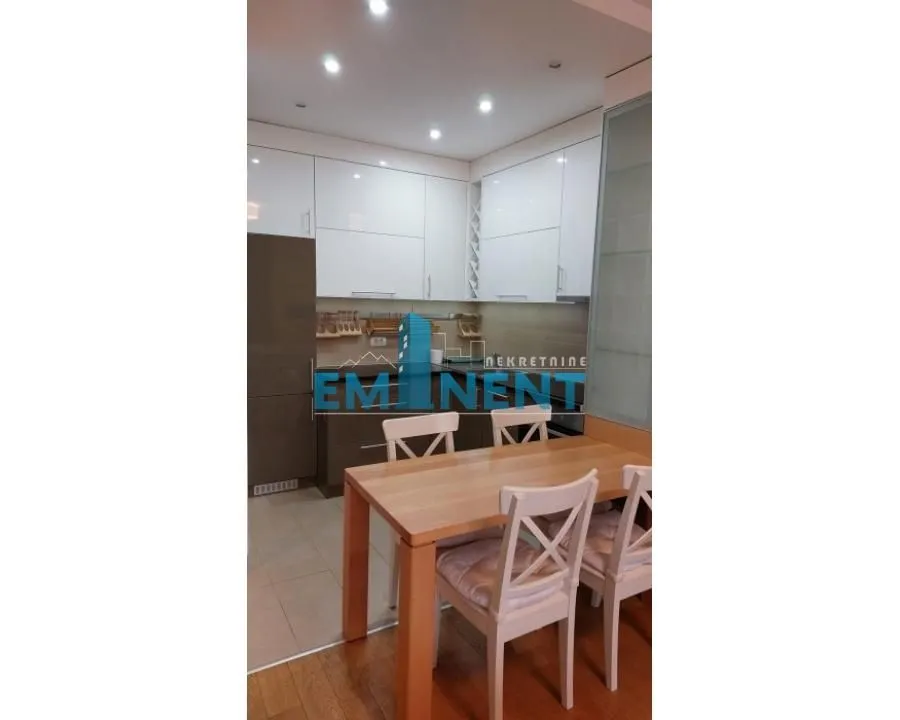 Kitchen with a dining table and white cabinetry.