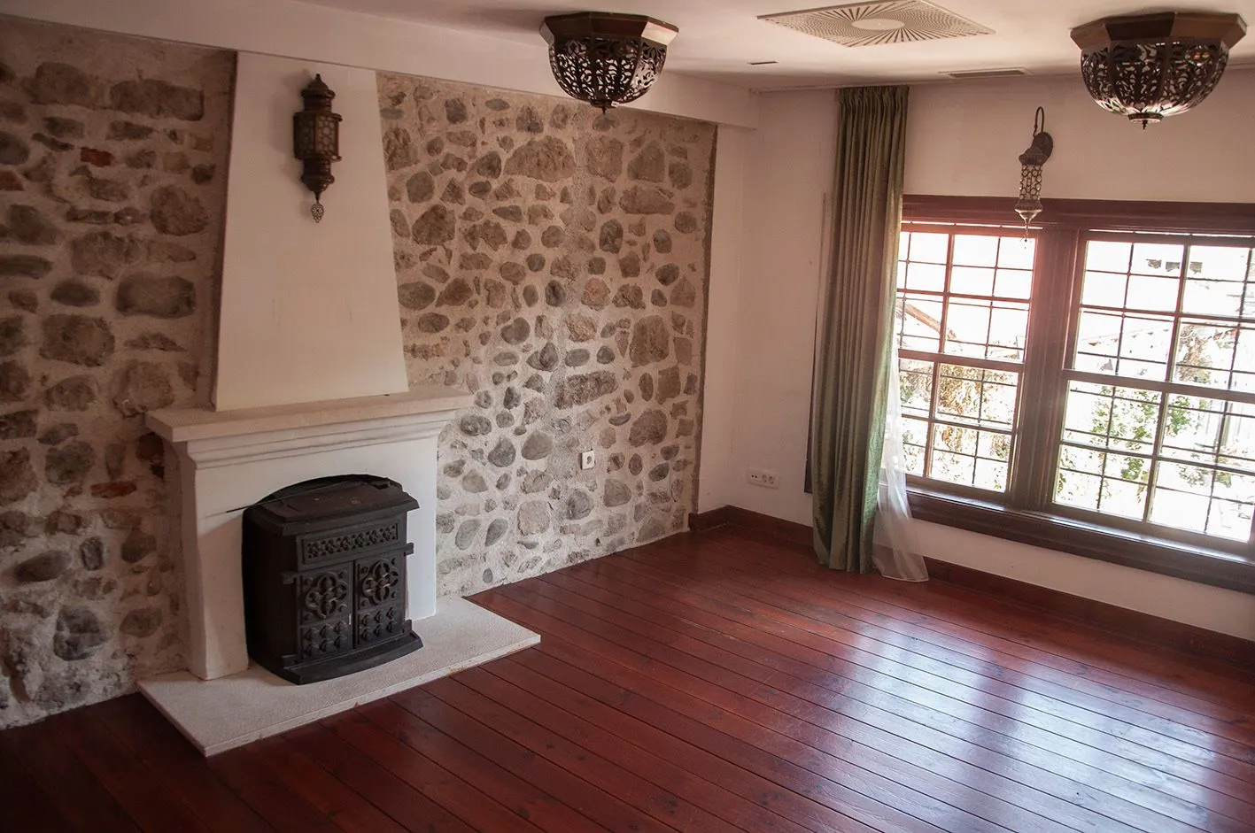 Living room with a fireplace and a stone wall.