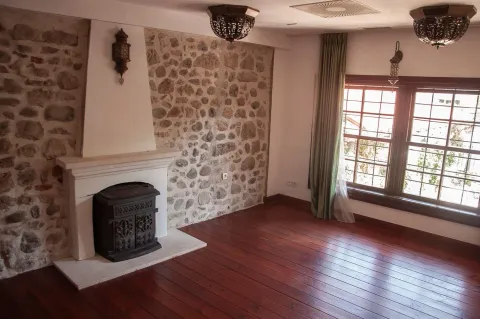Living room with a fireplace and a stone wall. - image 8