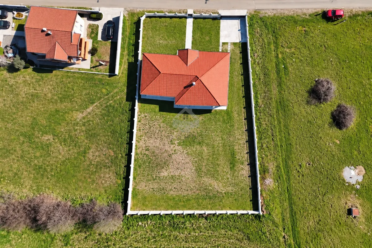 Aerial view of the house with a fenced yard.
