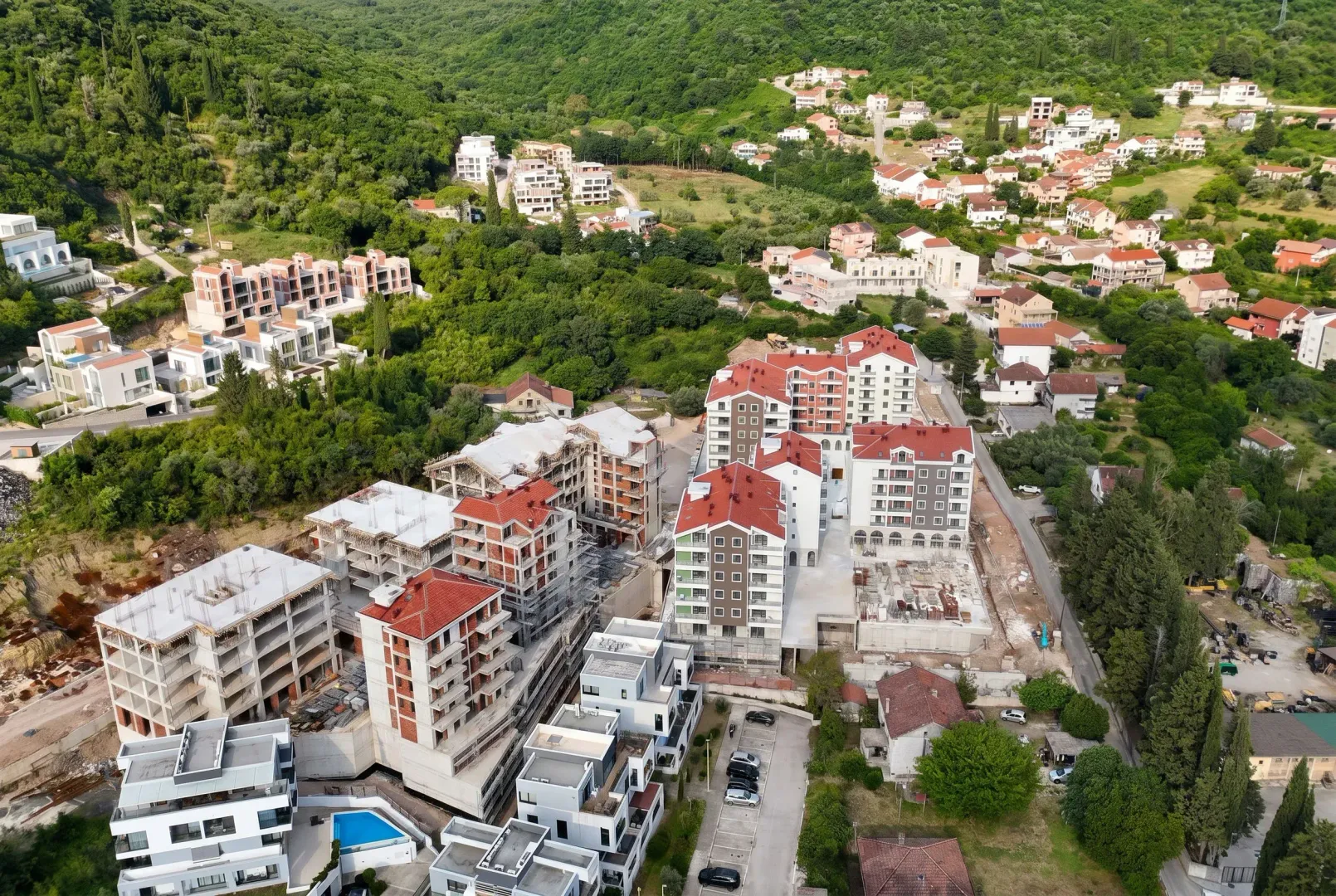 Pogled iz vazduha na stambeni kompleks u izgradnji i okolno naselje.