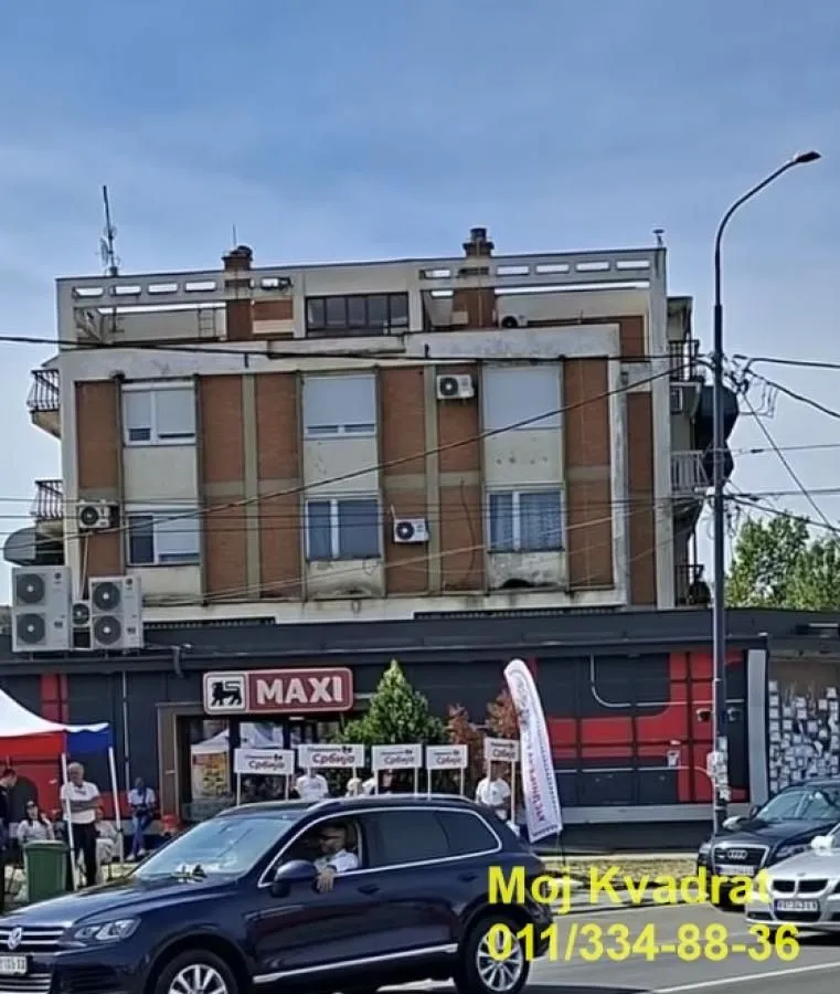Pogled na spoljašnjost zgrade sa poslovnim prostorom u prizemlju.