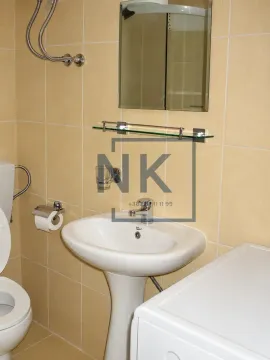 Smaller bathroom with a washbasin, mirror, and toilet bowl tiled with ceramic tiles. - image 11
