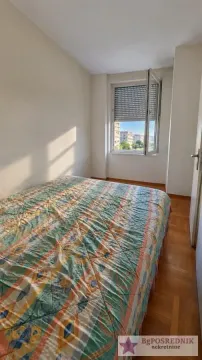 A bedroom with a double bed and a window overlooking surrounding buildings. - image 6