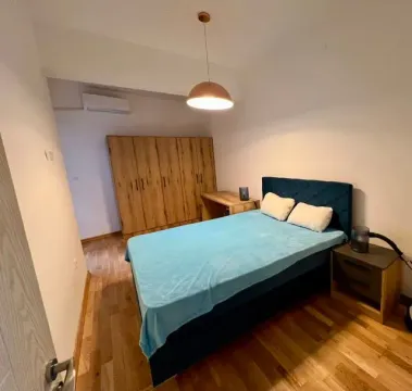 Furnished bedroom with a double bed, wardrobe, and wooden flooring. - image 6