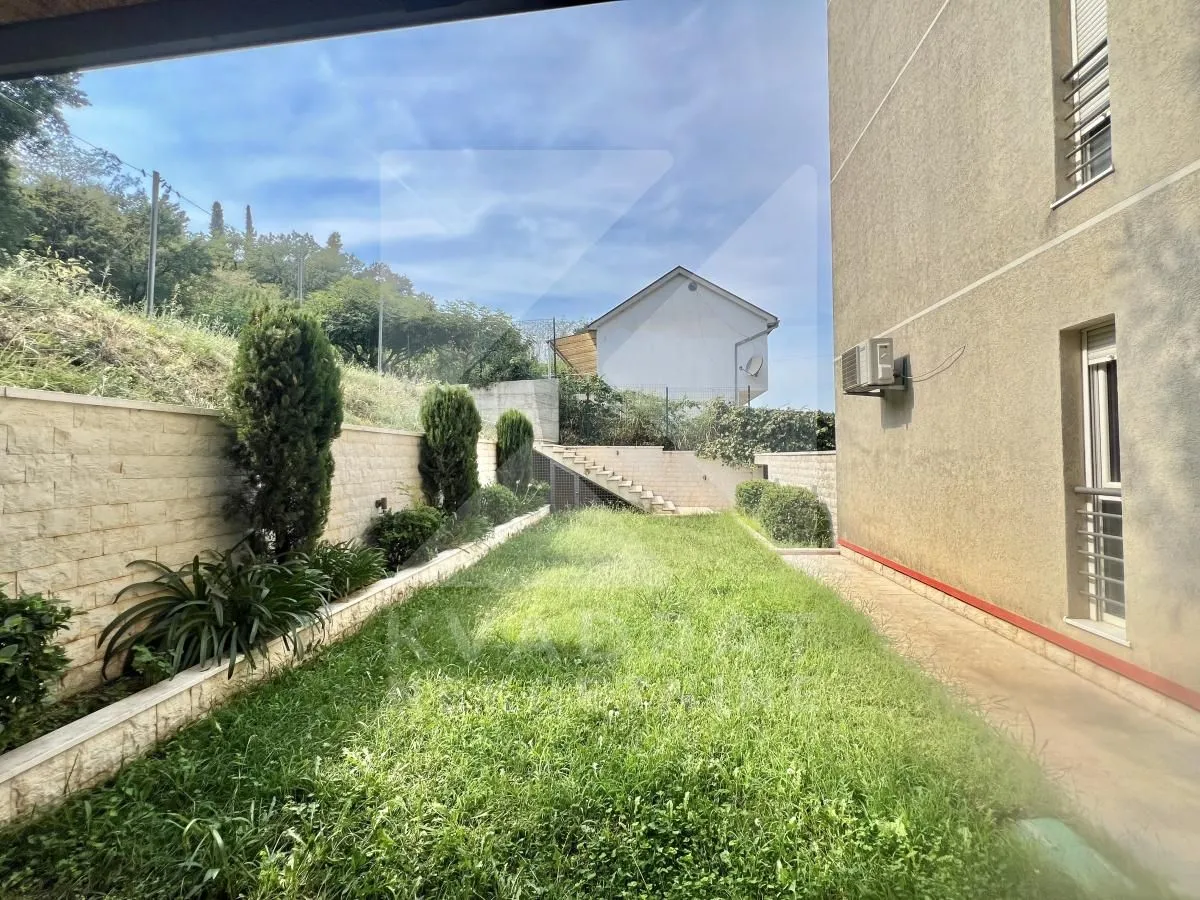 Landscaped courtyard with a lawn and walkway next to the building.
