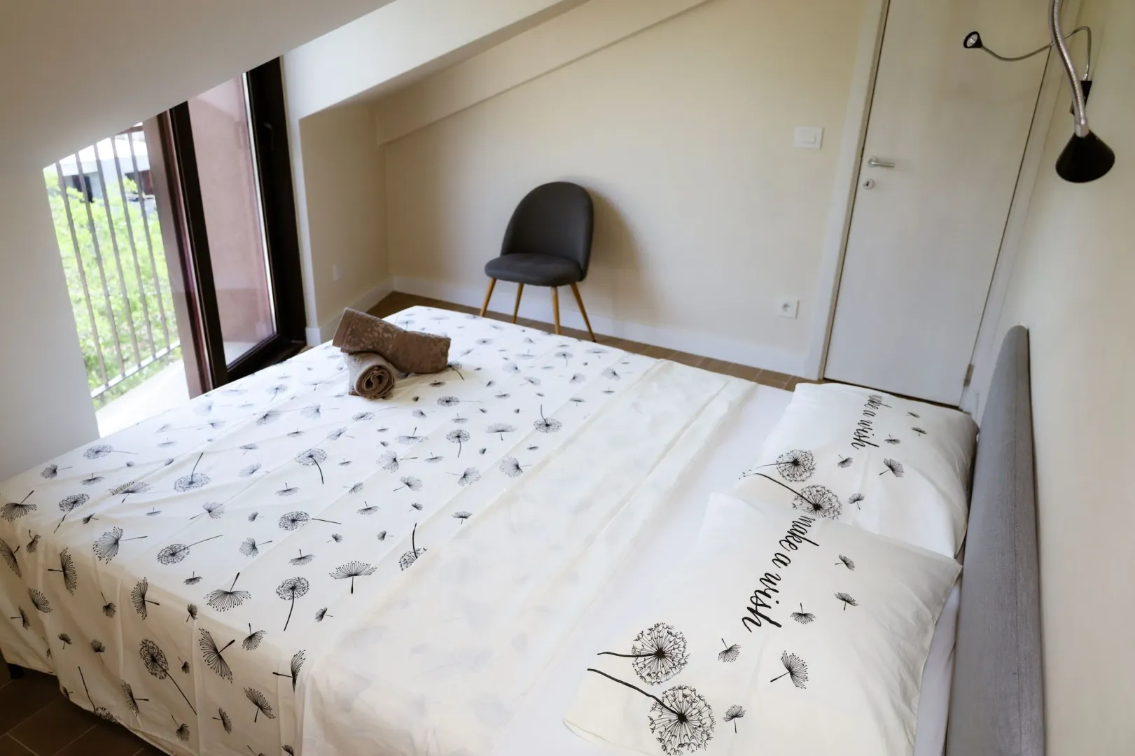 Spavaća soba sa bračnim krevetom i izlazom na balkon.