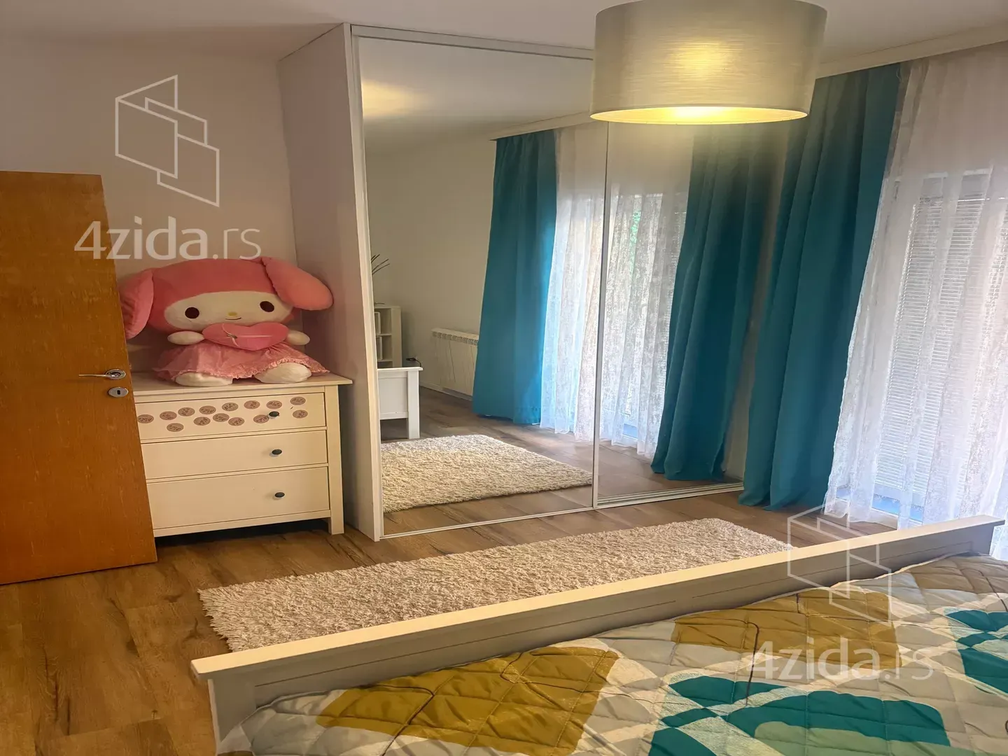 Bedroom with a double bed, a large mirrored wardrobe, and a soft toy.