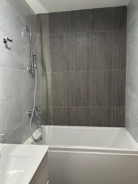 Moderno kupatilo sa kadom i sivim pločicama. - image 7