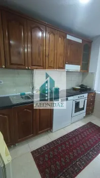 Kitchen with wooden cabinetry, a sink, and built-in appliances. - image 13