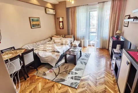 Living room with sofa set, dining table, and parquet flooring. - image 3