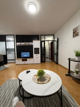 Living room with a seating area, TV unit, and coffee table. - image 7
