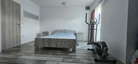 Spavaća soba sa bračnim krevetom, noćnim stočićima i spravom za vježbanje. - image 4