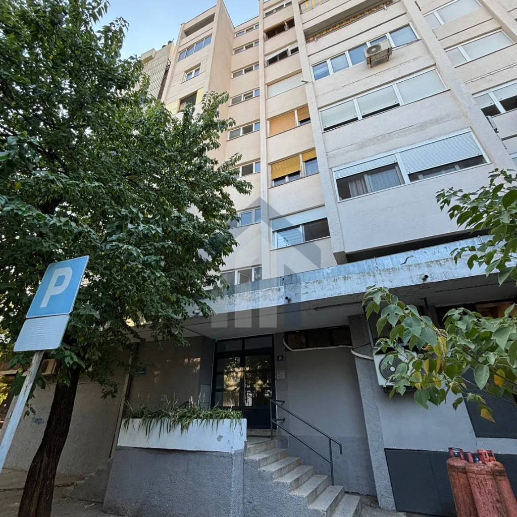 Exterior view of an apartment building with entrance and stairs.