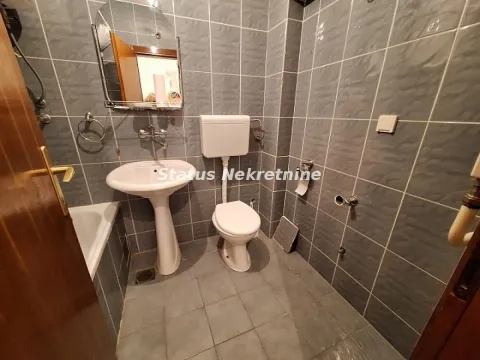 Manje kupatilo obloženo sivim pločicama sa umivaonikom, WC šoljom i kadom. - image 9