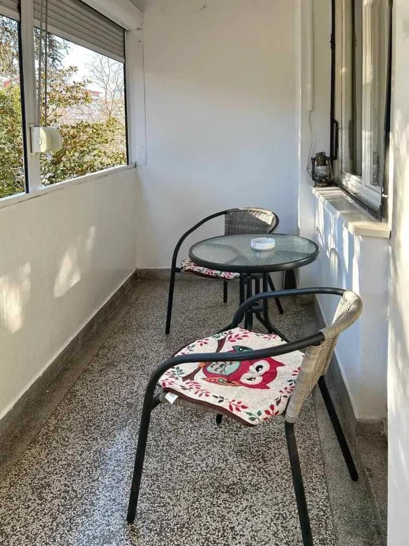 Uredna terasa sa okruglim stolom i dvije stolice.