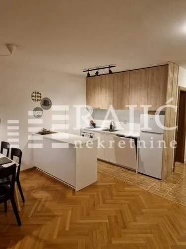 Moderna kuhinja sa šankom i trpezarijom u sklopu dnevnog boravka.