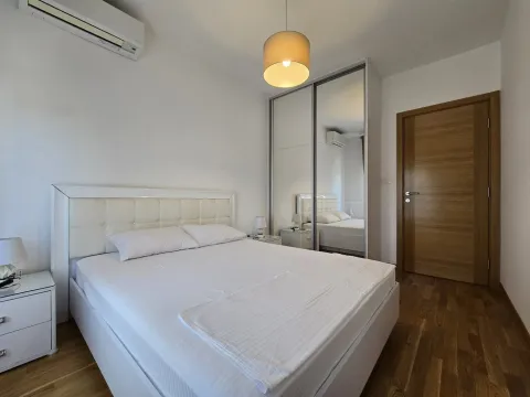 Bright bedroom with a double bed, large mirrored wardrobe, and wooden flooring. - image 9