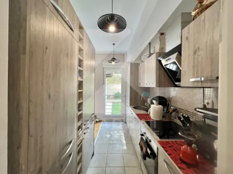 Corner kitchen with wooden cabinets and access to the terrace. - image 3