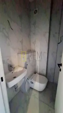 Manje kupatilo obloženo mermernim pločicama sa umivaonikom i šoljom. - image 7