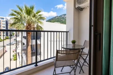 Small furnished balcony with a table, chairs, and surrounding view. - image 6