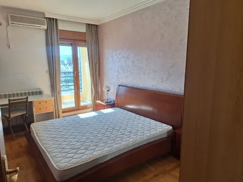 Furnished bedroom with a double bed, desk, and balcony access. - image 7