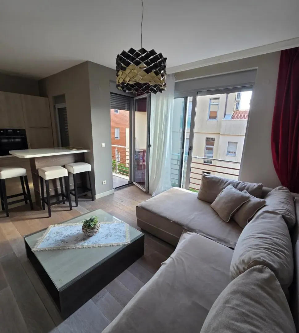 Living room with a sectional sofa, dining area, and access to the terrace.