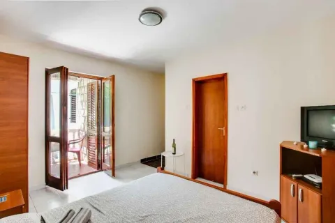 Svijetla spavaća soba sa izlazom na balkon i drvenim namještajem. - image 6