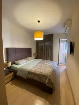 Furnished bedroom with a double bed, nightstands, and air conditioning. - image 3