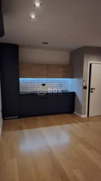 Moderna kuhinja tamnih elemenata sa drvenim detaljima i ugrađenom rasvetom. - image 5