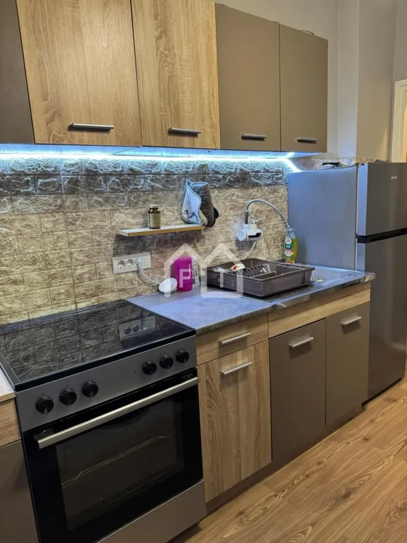 Smaller kitchen with wooden cabinets, a stove, and a refrigerator.