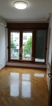 Prazna soba sa drvenim podom i velikim prozorom. - image 2