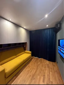 Dnevna soba sa žutim trosjedom, ugradnim plakarima i televizorom na zidu. - image 3
