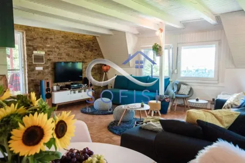 Spacious living room with a sofa, TV, and dining table in the foreground. - image 10