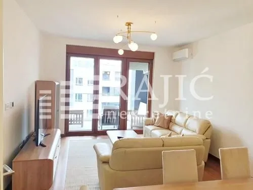 Spacious living room with sofa set and terrace access.