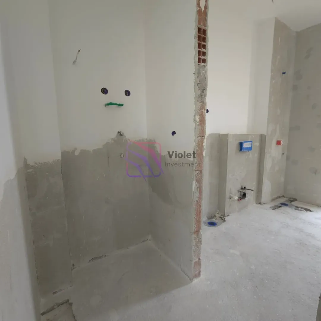 Bathroom under construction with exposed plumbing installations.