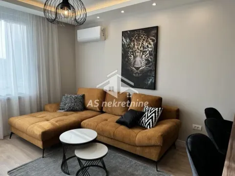Dnevni boravak sa garniturom, stočićem i slikom leoparda na zidu. - image 2