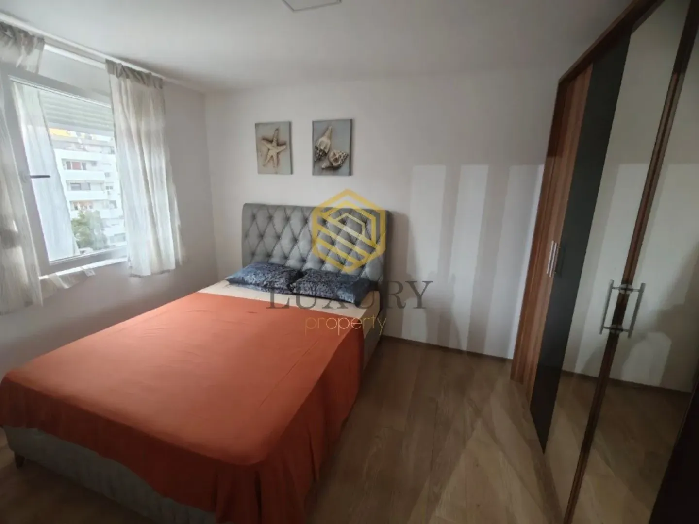 Furnished bedroom with a double bed and a fitted wardrobe.