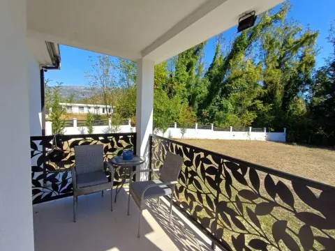 Covered terrace with seating furniture and a view of the yard. - image 8