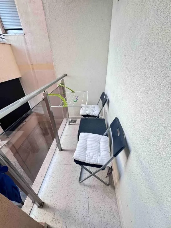 Manji balkon sa stolicama i sušilicom za veš.
