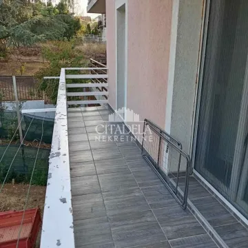 Prostrana popločana terasa sa ogradom i pogledom na dvorište. - image 12