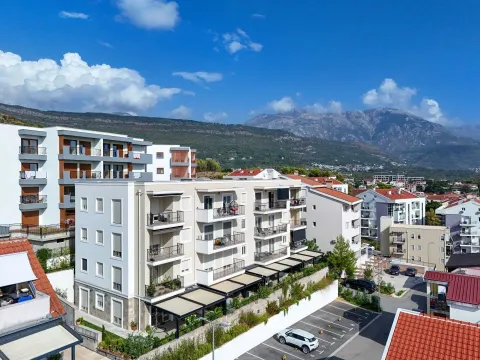Pogled iz vazduha na stambenu zgradu i okolno naselje sa planinama u pozadini. - image 21