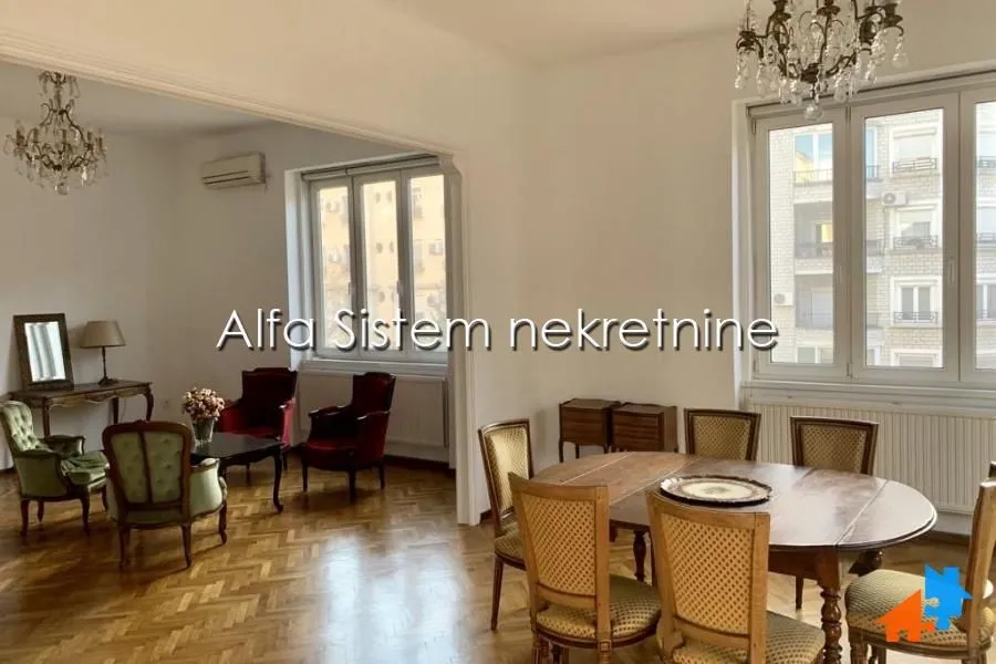 Prostrana dnevna soba sa trpezarijom i klasičnim nameštajem.