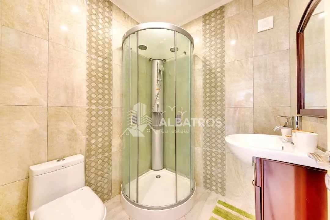 Bathroom equipped with a shower cabin, washbasin, and toilet.