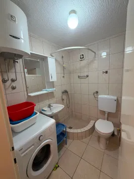 Kupatilo opremljeno tuš kabinom, umivaonikom, wc šoljom i mašinom za veš. - image 6