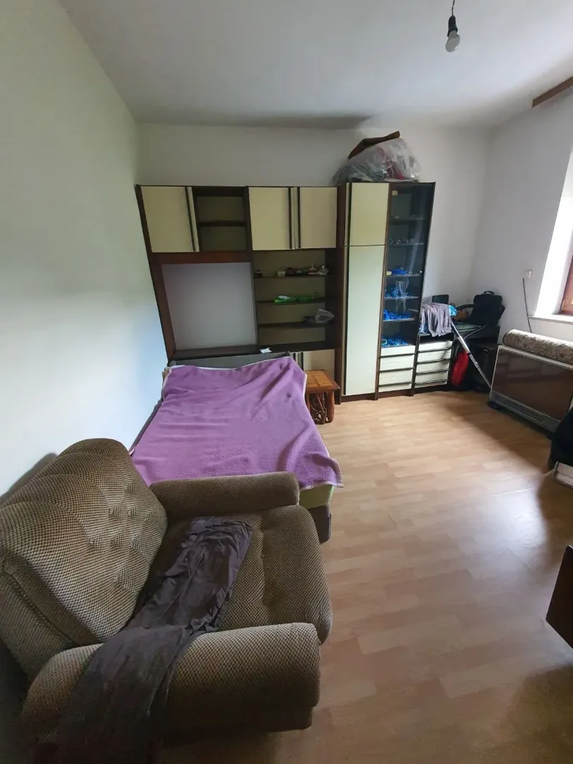 Jednostavna spavaća soba sa krevetom i ormarima.
