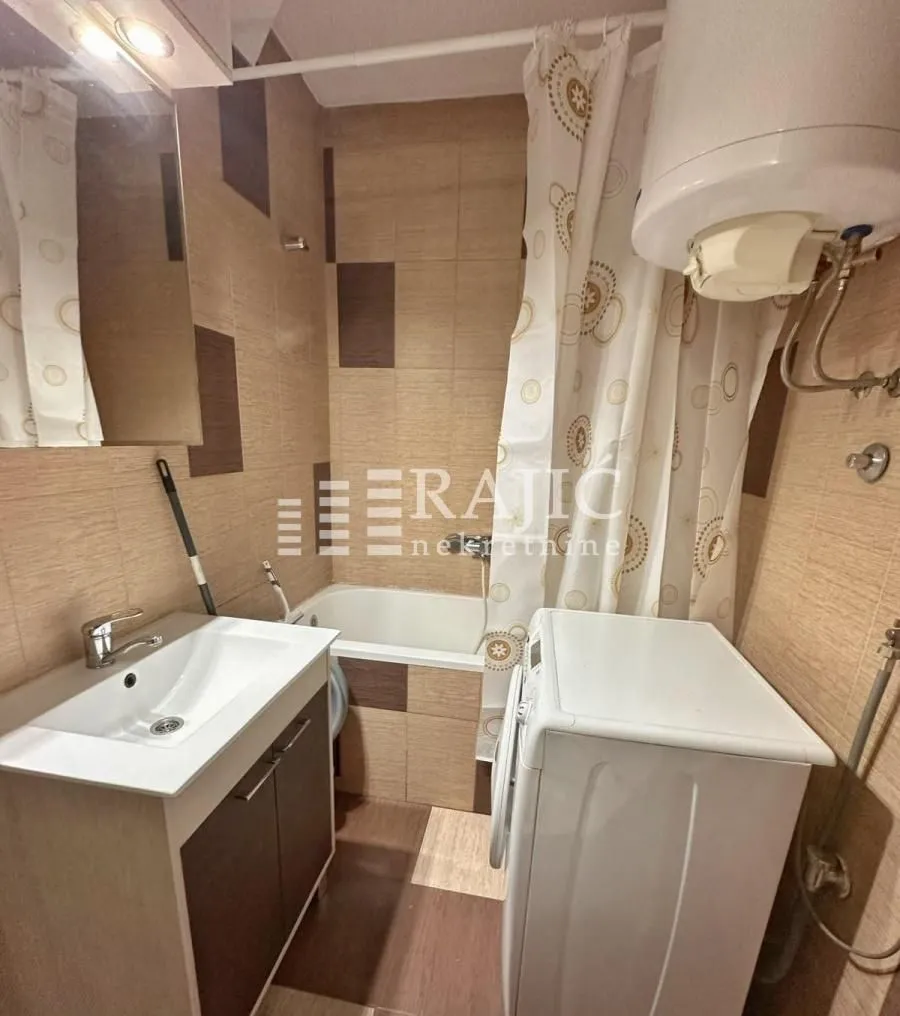 Small bathroom with a sink, bathtub, and washing machine.