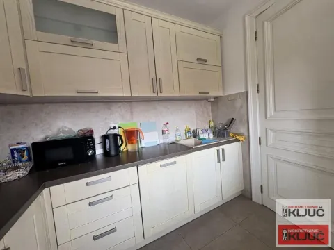Kuhinja sa svetlim drvenim elementima i radnom površinom. - image 6