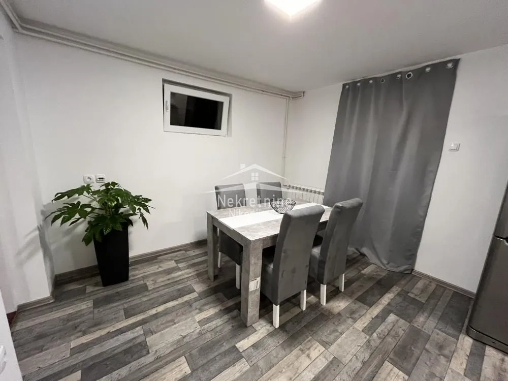 Dining area with a table, four chairs, and a potted plant.