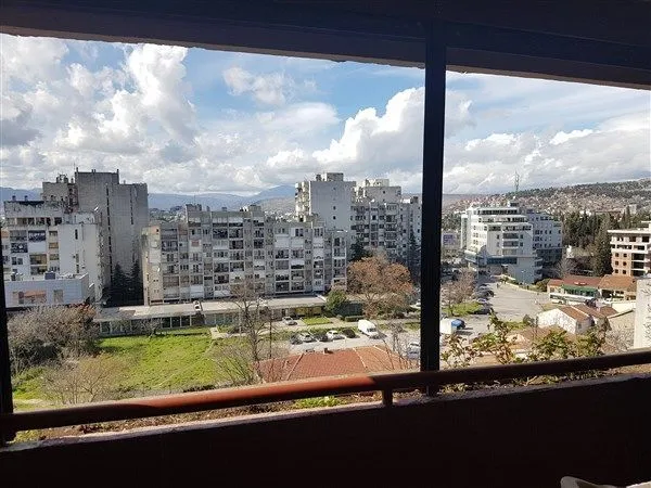 Pogled sa terase na okolne stambene zgrade i gradski pejzaž.